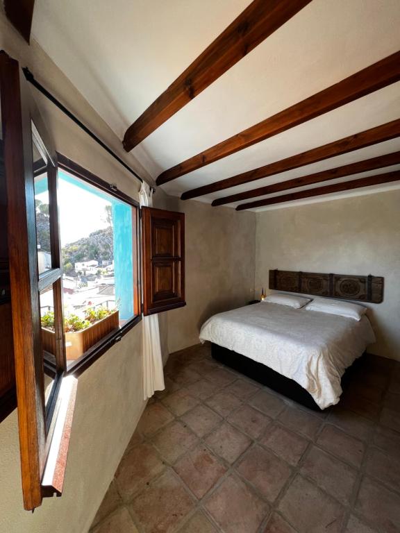 1 dormitorio con cama y ventana en Casa Rural con vistas espectaculares, en Montejaque