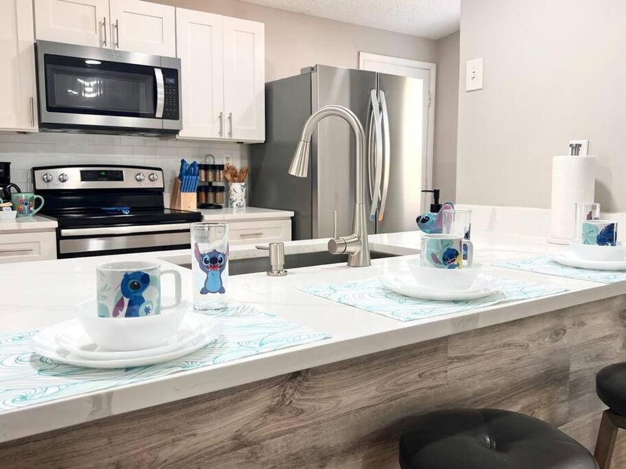 um balcão de cozinha com duas chávenas e pratos em Quiet home in Metrowest em Orlando