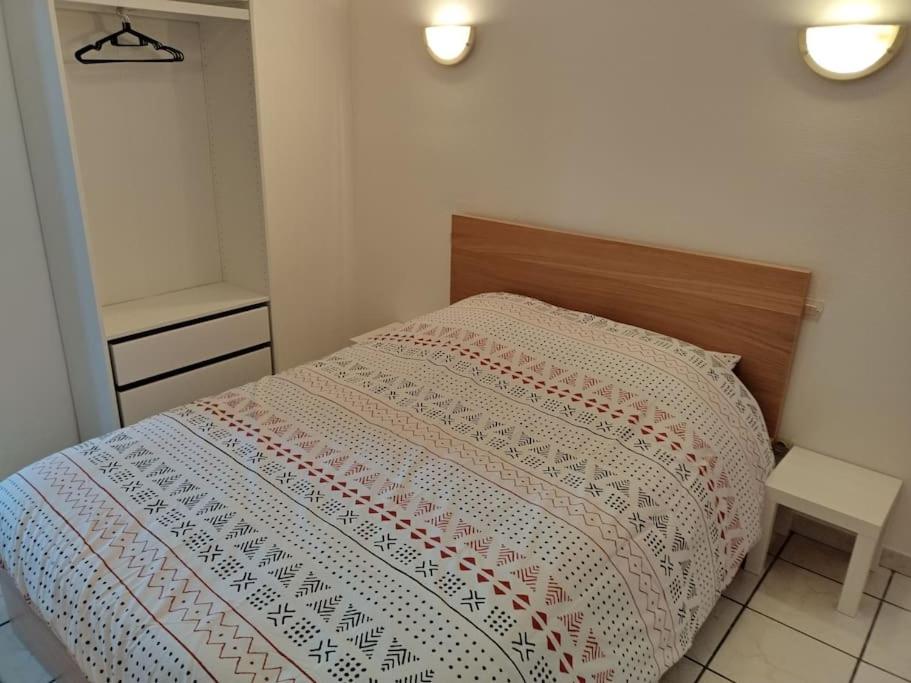 un pequeño dormitorio con una cama con una manta. en Spacieuse et confortable maison avec garage, en Anzin