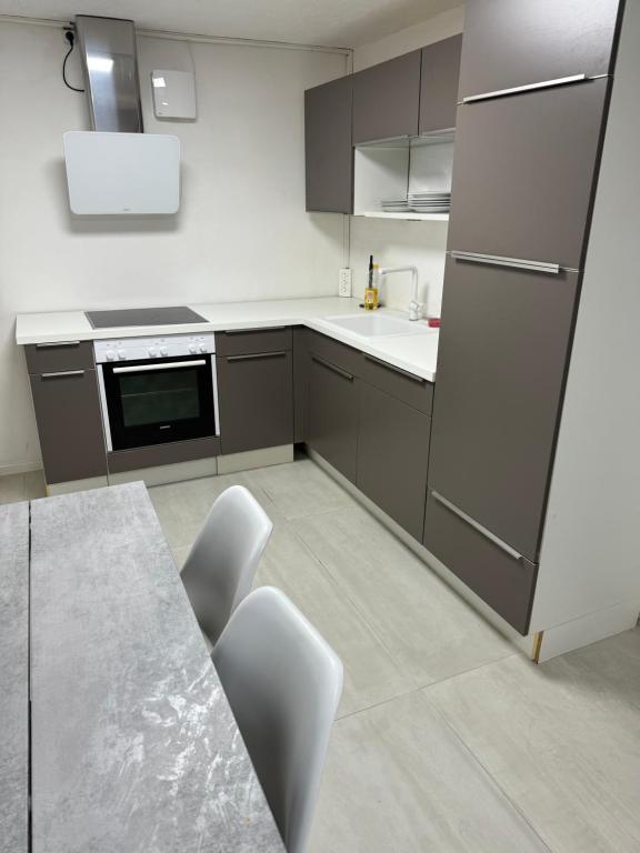 cocina con armarios grises, mesa y sillas en Italian Rooms 9, en Aalborg