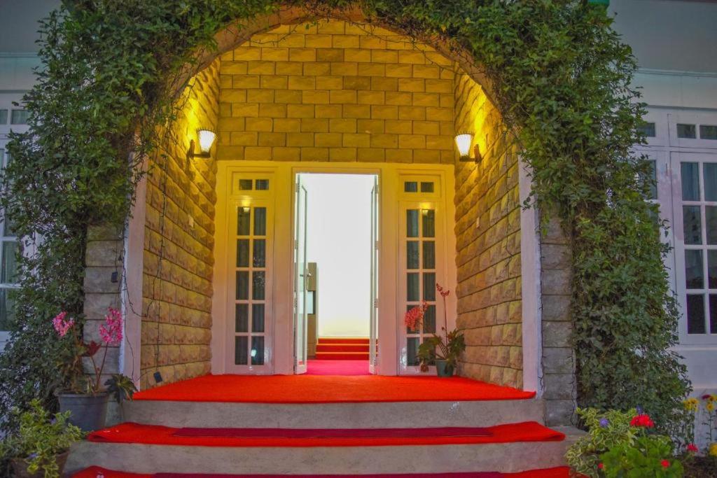 an archway leading to a door with a red carpet at The Royal Terrace Holiday Bungalow in Nuwara Eliya