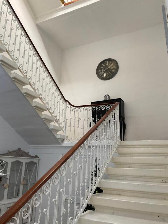 a staircase in a house with a clock on the wall at Privilge Gzira in Il-Gżira