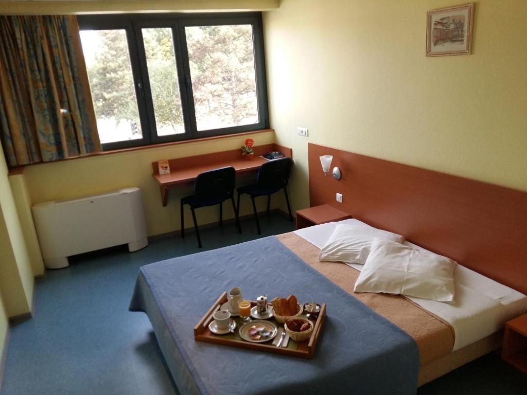 una habitación de hotel con una bandeja de comida en una cama en Hotel Restaurant Niemerich, en Pulversheim