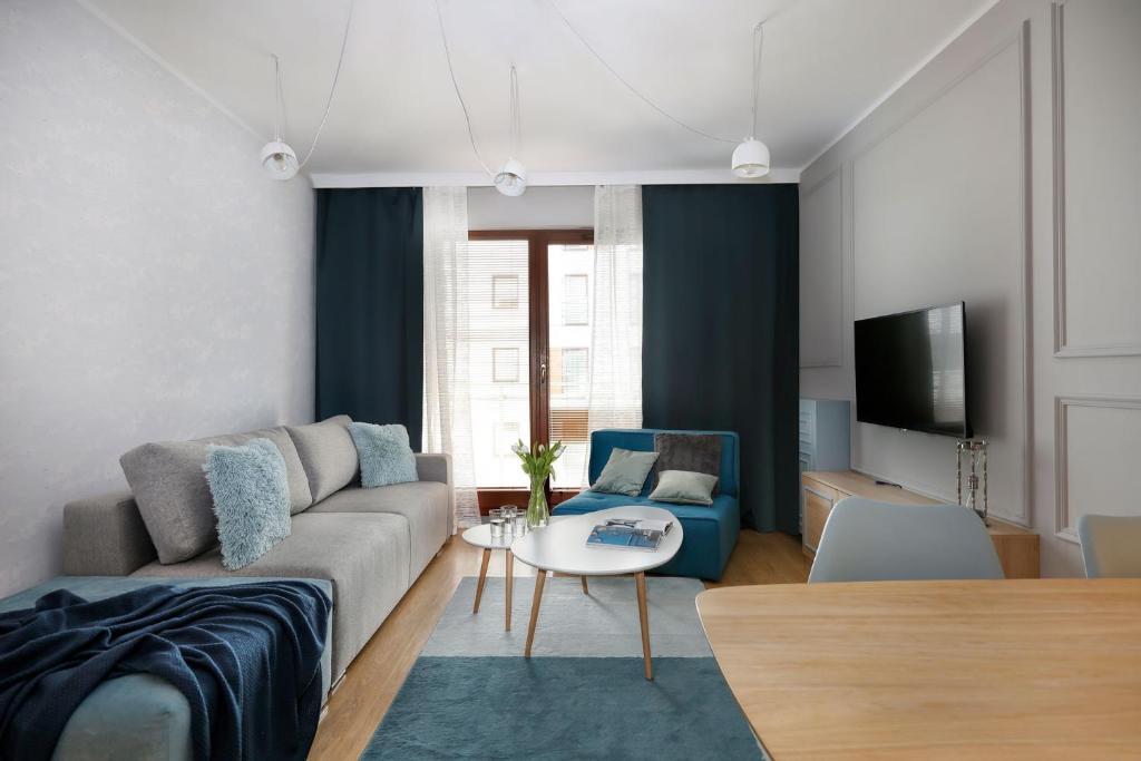 a living room with a couch and a table at City Center - Riverside by Apartmore in Gdańsk