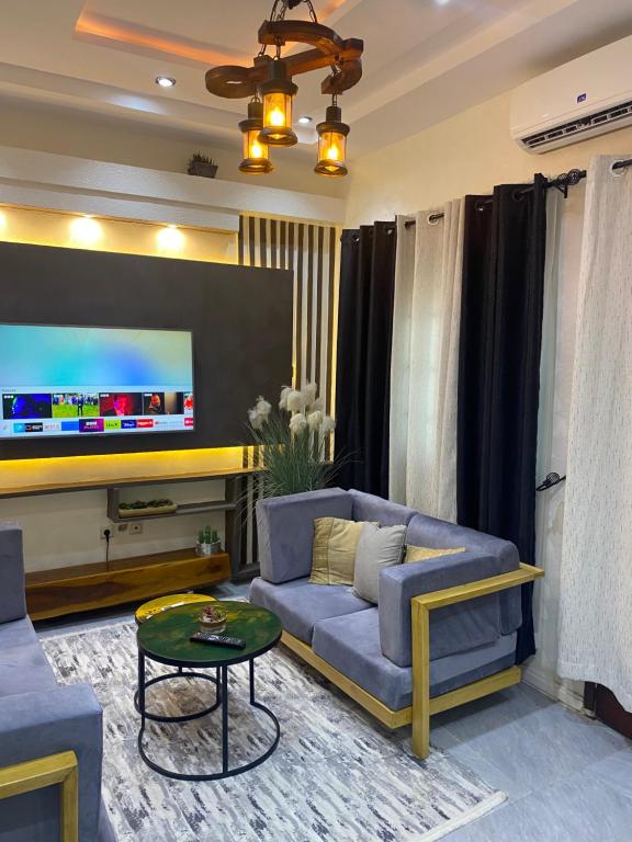 een woonkamer met een bank en een flatscreen-tv bij Emefa Room in Cotonou