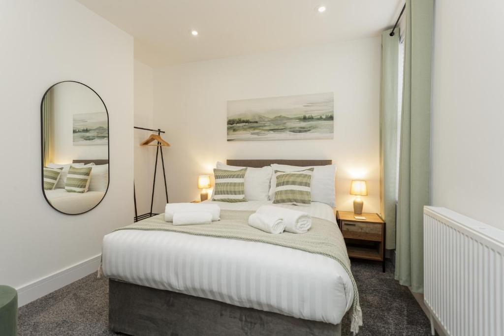 een slaapkamer met een bed met twee handdoeken erop bij Henderson Lodge - Cosy, modern 3 bed 2 bath house in Portsmouth