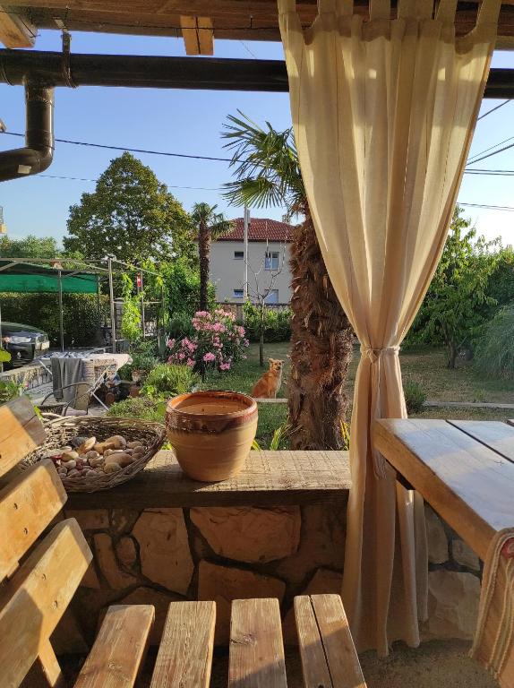 - une table avec un bol de nourriture et un rideau dans l'établissement Zoran Vukusic Apartment, à Kostrena