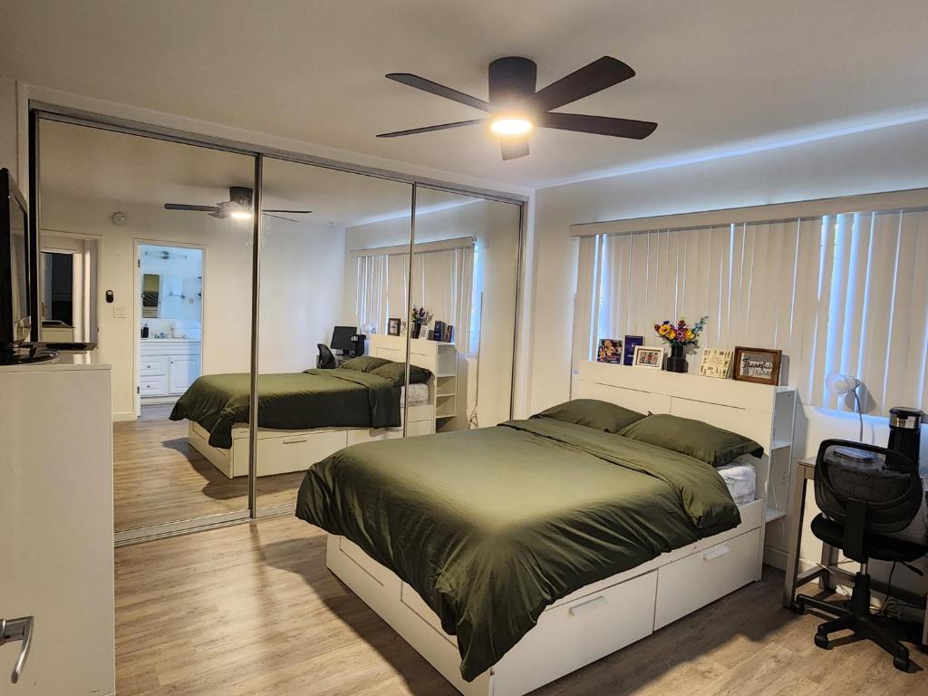 a bedroom with two beds and a ceiling fan at Cozy Private Room & Bath Central Location LA in Los Angeles
