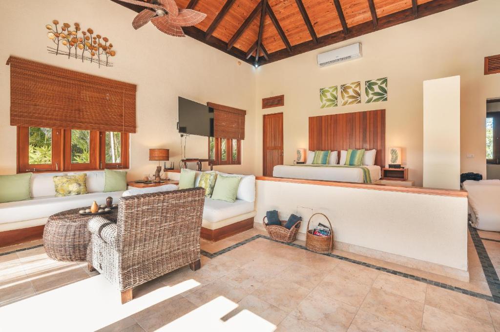 a living room with a couch and a bed at Newly added Tropical Bungalow at Green Village in Punta Cana