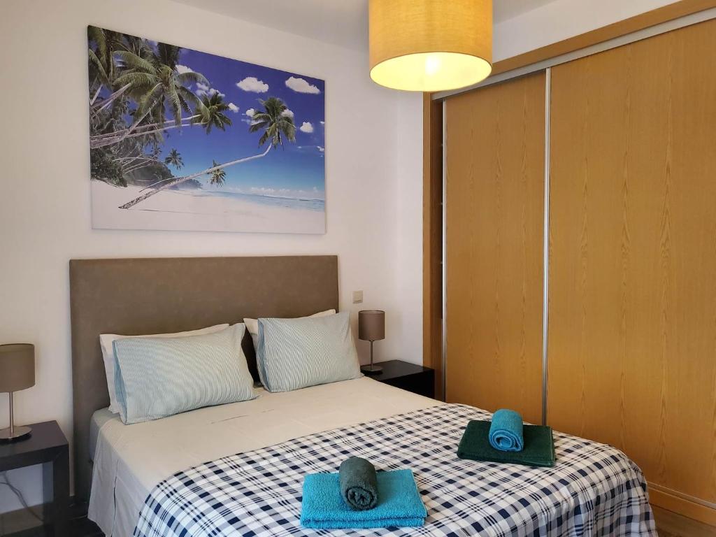 een slaapkamer met een bed met blauwe handdoeken bij "Villa Sun View over the Sea" - B in Albufeira