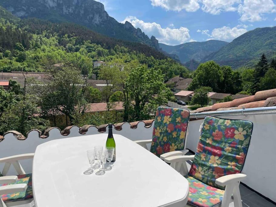 Una botella de vino sentada en una mesa con sillas en Cosy house with roof terrace and stunning views, en Axat