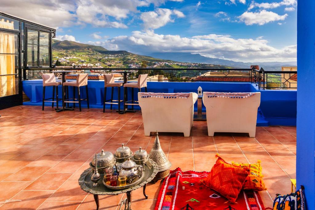 een balkon met een tafel en stoelen en uitzicht bij Ryad A&B Sarai in Chefchaouene