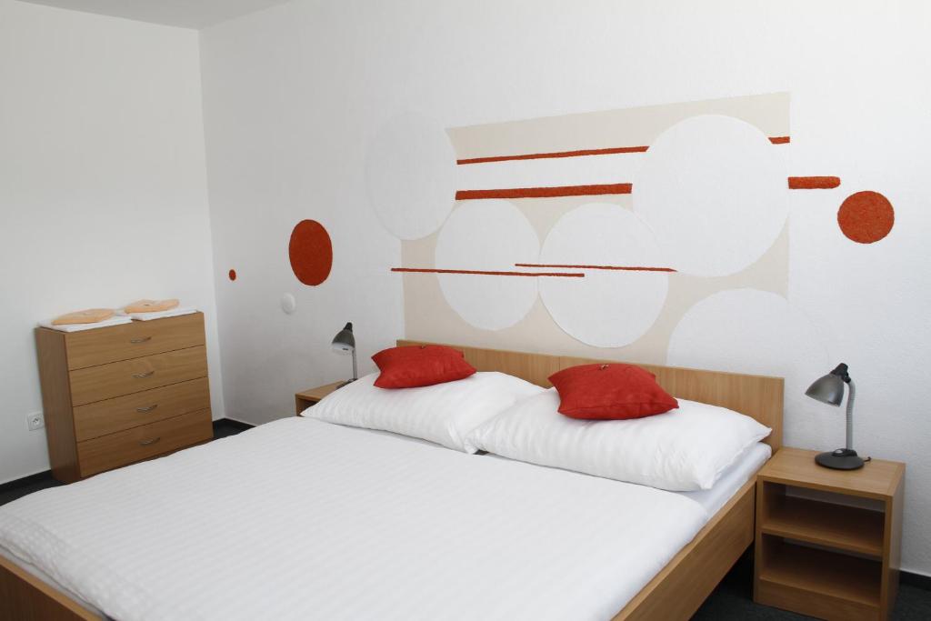 a bedroom with a white bed with red pillows at Sport Hotel Ticha Orlice in Ústí nad Orlicí
