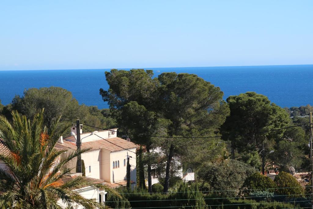 une maison sur une colline avec l'océan en arrière-plan dans l'établissement esterel-plage, à Saint-Raphaël