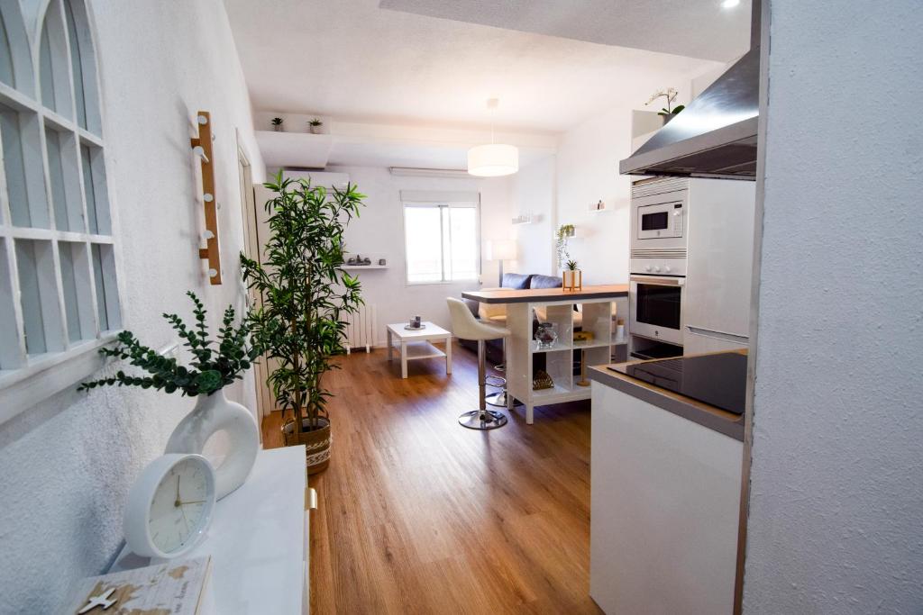 a kitchen with white cabinets and a table with a plant at Torremolinos. Plaza de Andalucía Apartment in Torremolinos