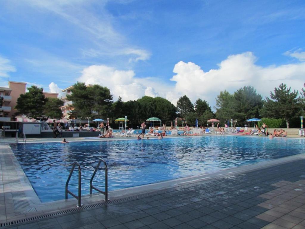 ein großer Pool mit vielen Menschen darin in der Unterkunft Holiday by the pool in our cozy flat - Beahost in Bibione