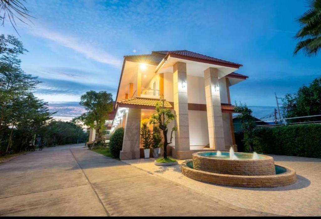 une maison avec une fontaine devant elle dans l'établissement JS Place THABO, à Tha Bo