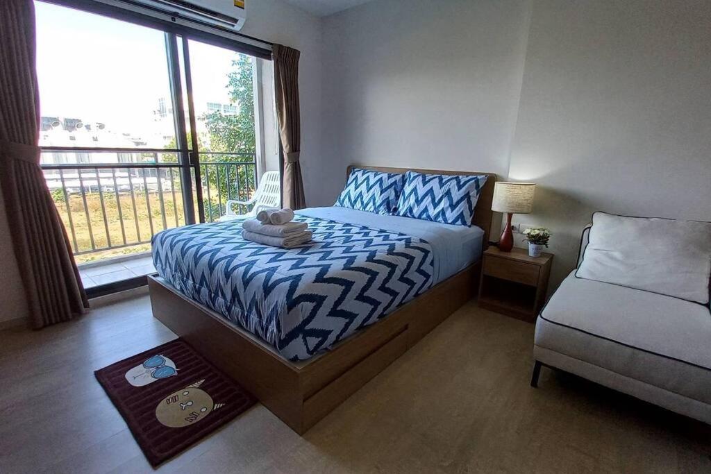 1 dormitorio con 1 cama, 1 silla y 1 ventana en ชีวิตมีความสุข สะดวกสบาย ที่ลากาสิต้าC368, en Hua Hin