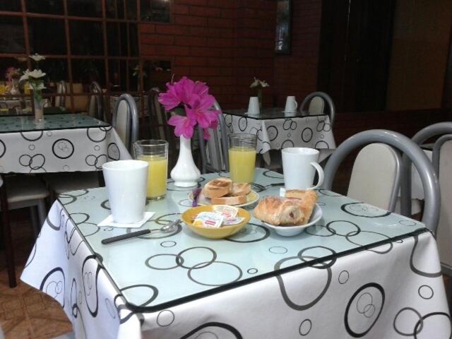 a table with a white table cloth with food on it at Hotel Colonial in Buenos Aires