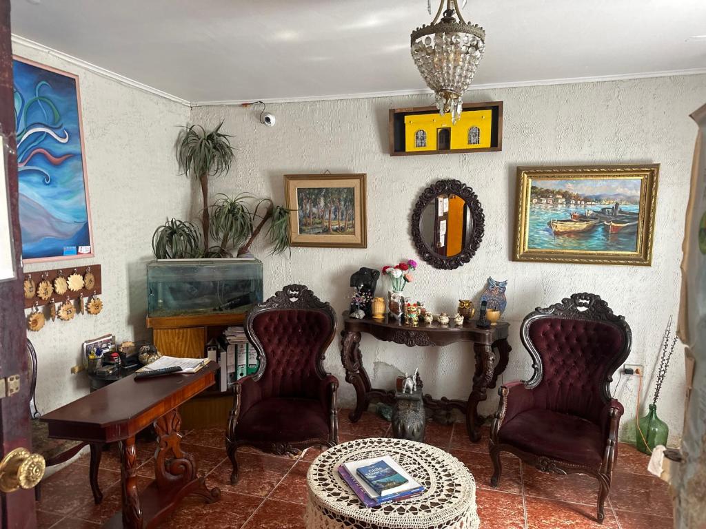 a living room with a desk and chairs and a table at Hotel El sol in Copiapó