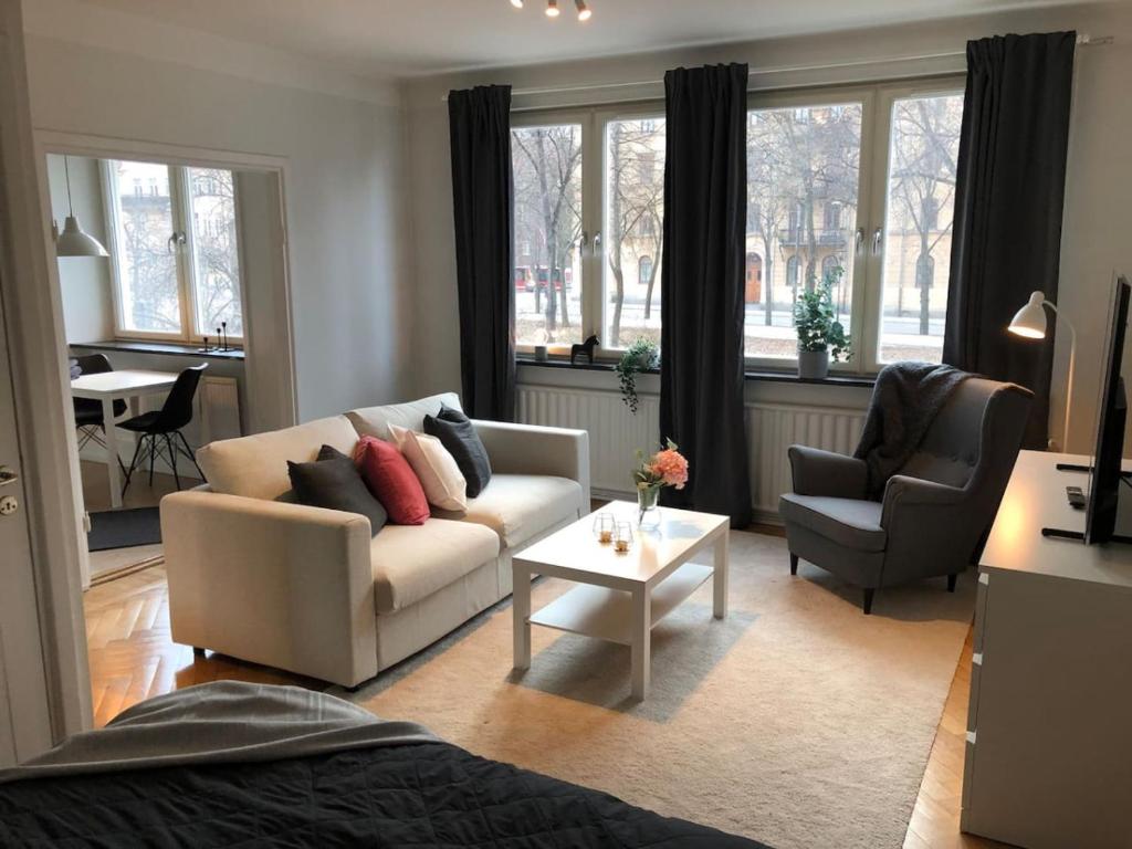 a living room with a couch and two chairs and a table at Lovely Ostermalm apartment in Stockholm