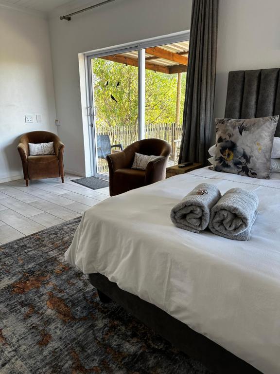 una camera da letto con un grande letto con due cuscini sopra di Villiera Guest Farm a Langebaan