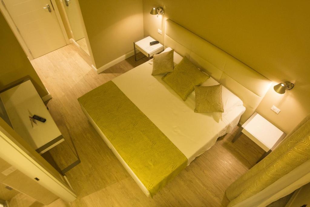 an overhead view of a bed with green pillows at Hotel Universal in Livorno