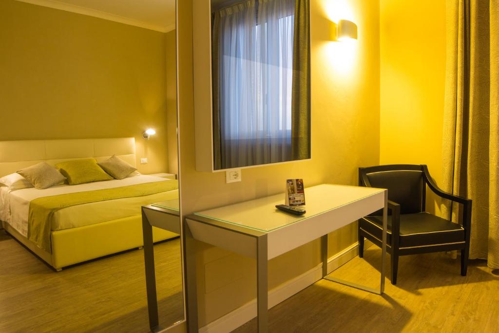 a hotel room with a bed and a desk and a bedroom at Hotel Universal in Livorno