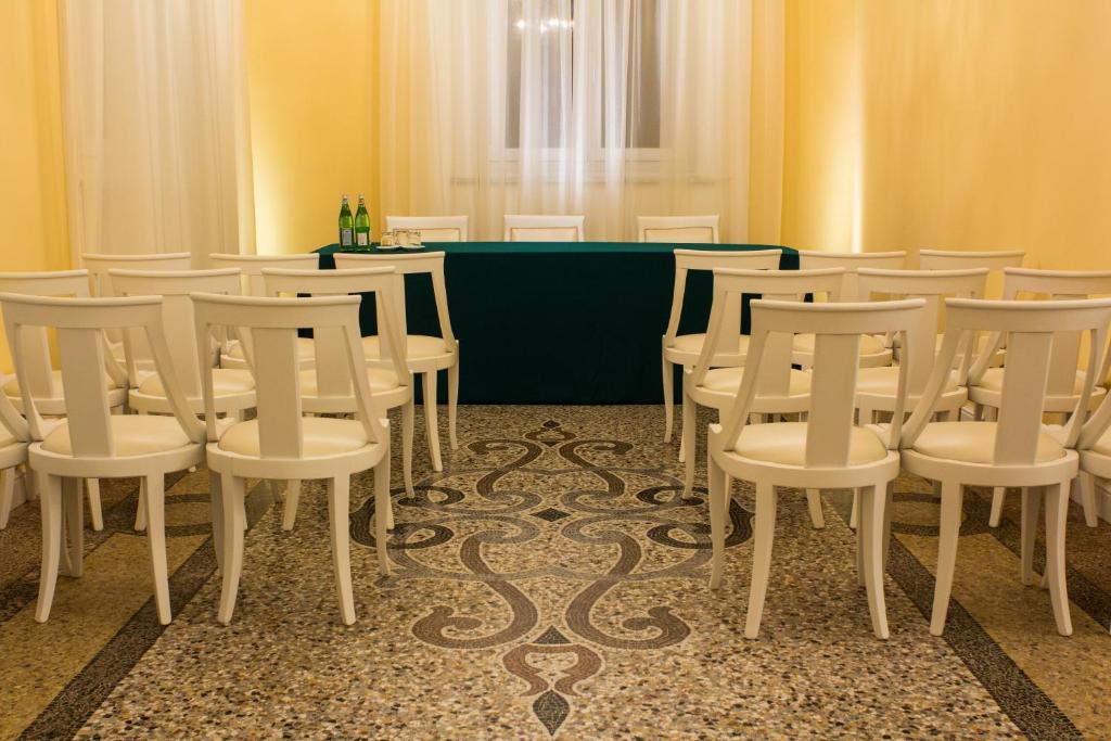 a room with a bunch of chairs and a table at Hotel Universal in Livorno