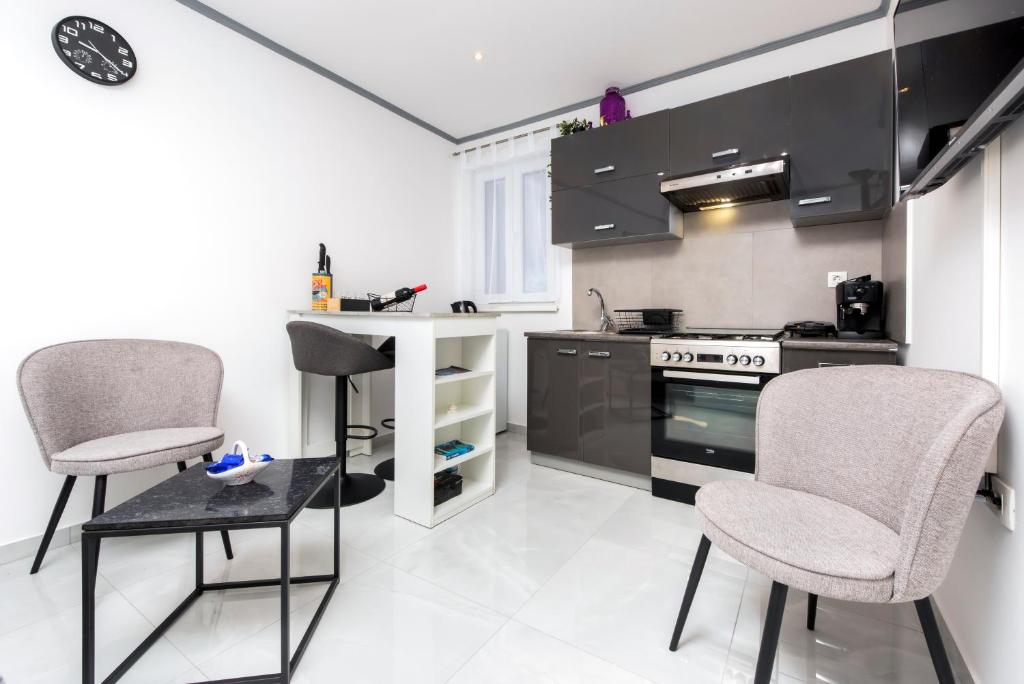 a kitchen with two chairs and a counter and a stove at Apartment Leo in Rovinj