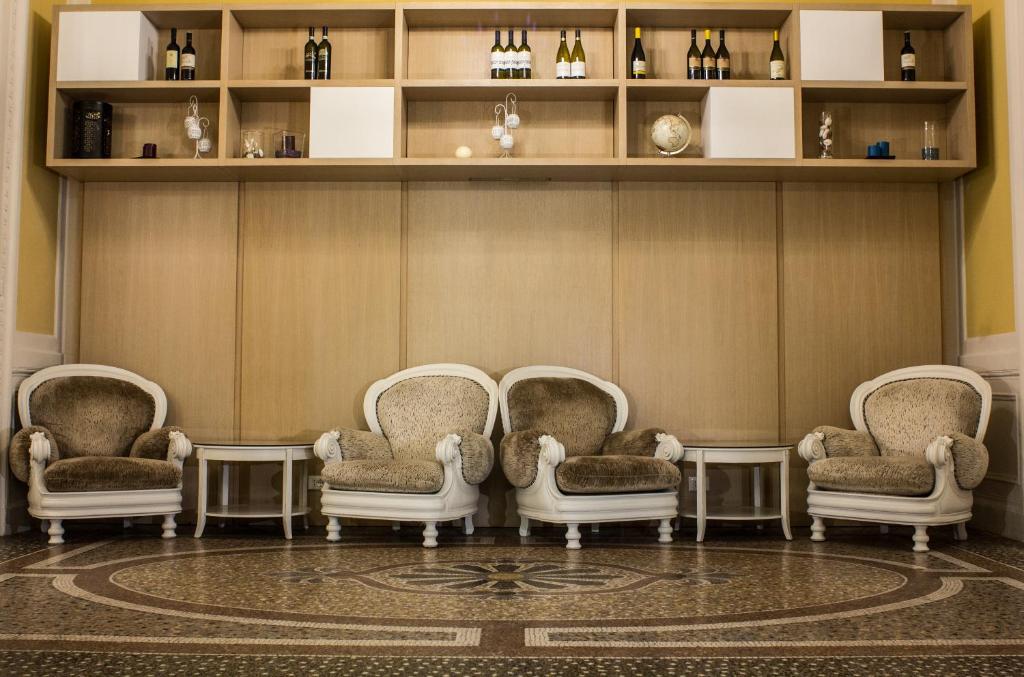 a group of chairs in a room with shelves at Hotel Universal in Livorno