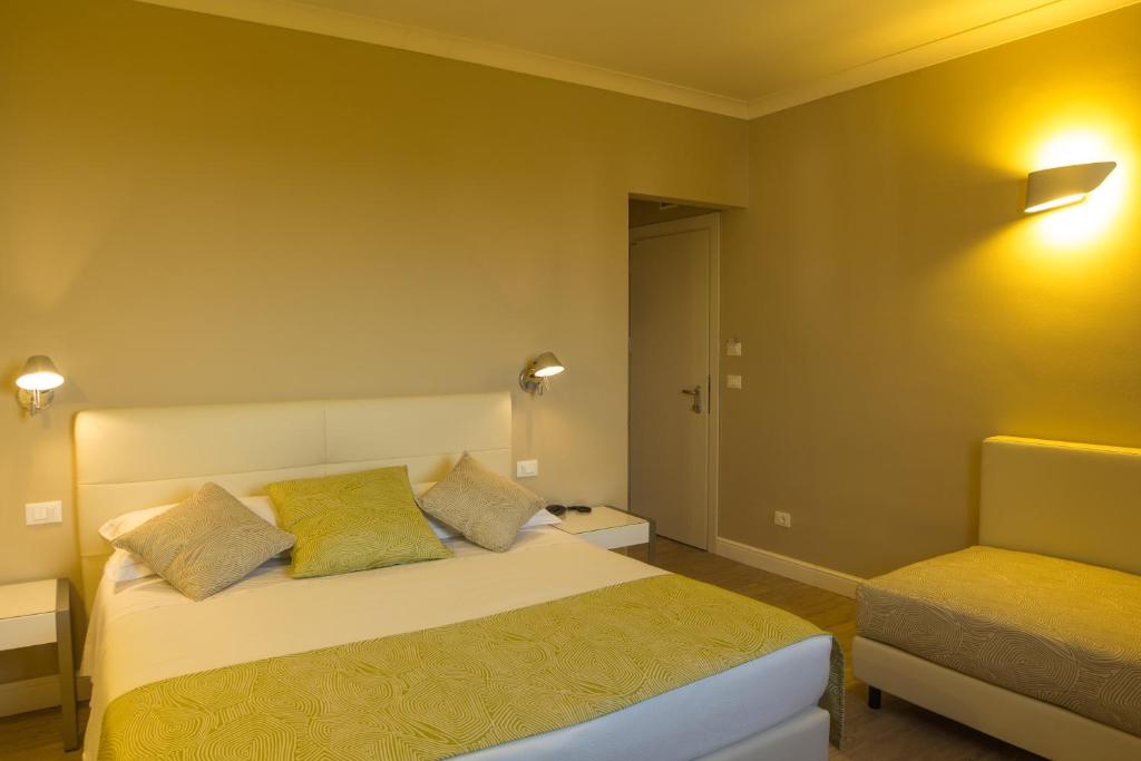 a bedroom with a bed and a chair at Hotel Universal in Livorno