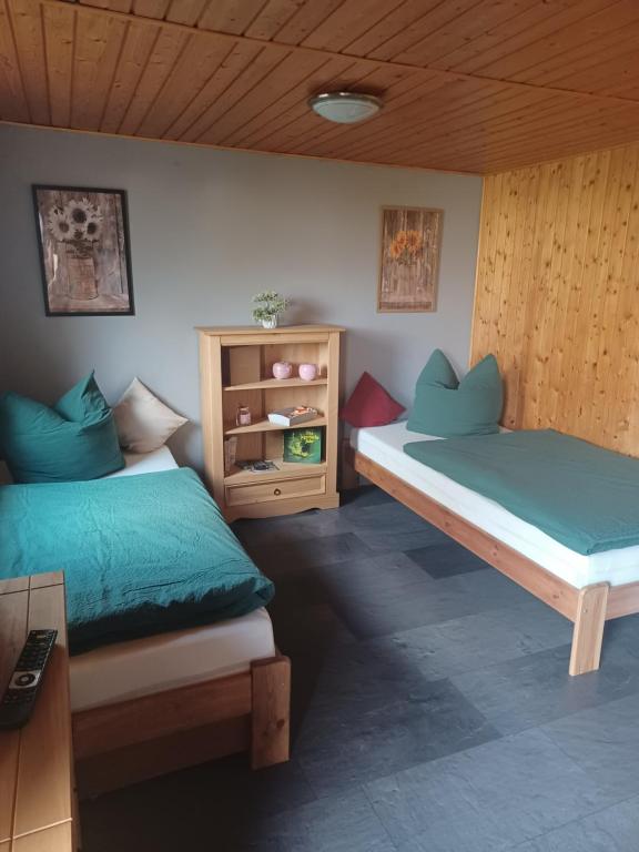 a bedroom with two beds and a wooden ceiling at Waldblick in Cavertitz