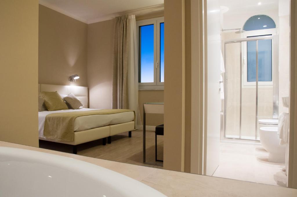 a hotel room with a bed and a bathroom at Hotel Universal in Livorno