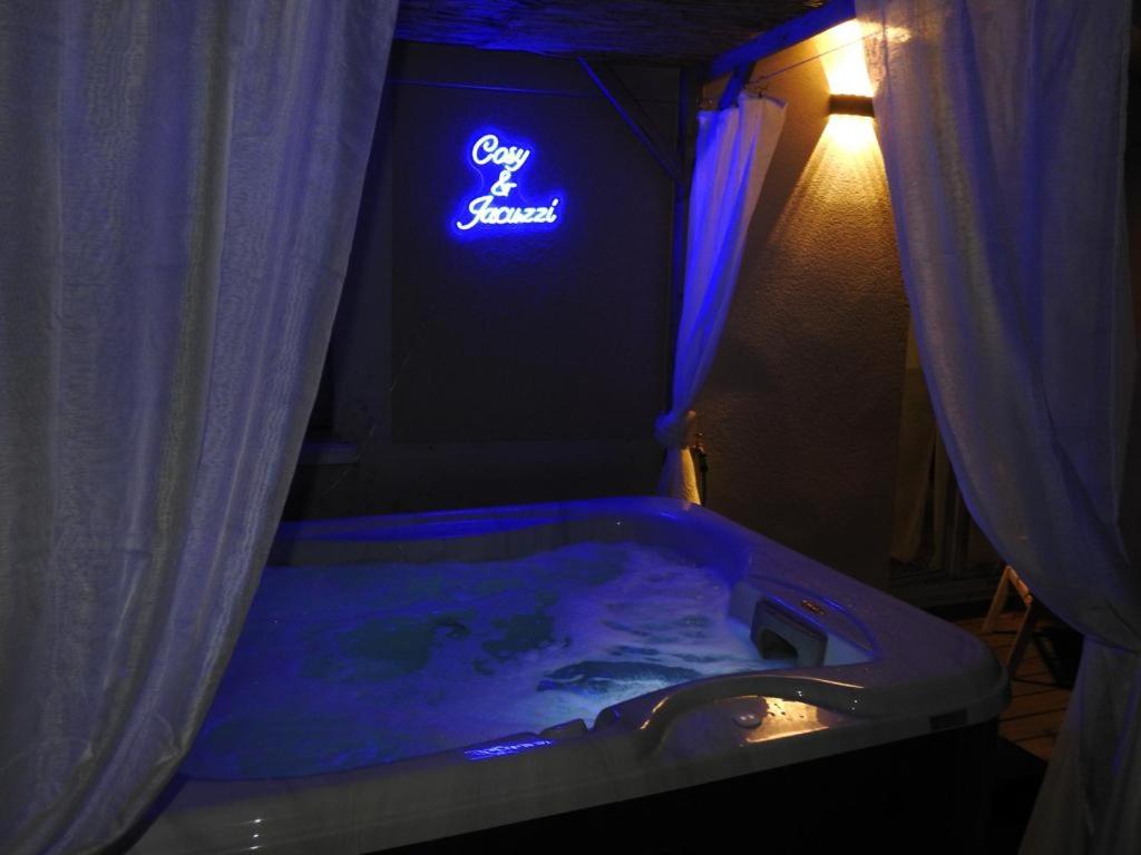 y baño con bañera y cartel iluminado. en Suite Cosy&Jacuzzi, en Cenon
