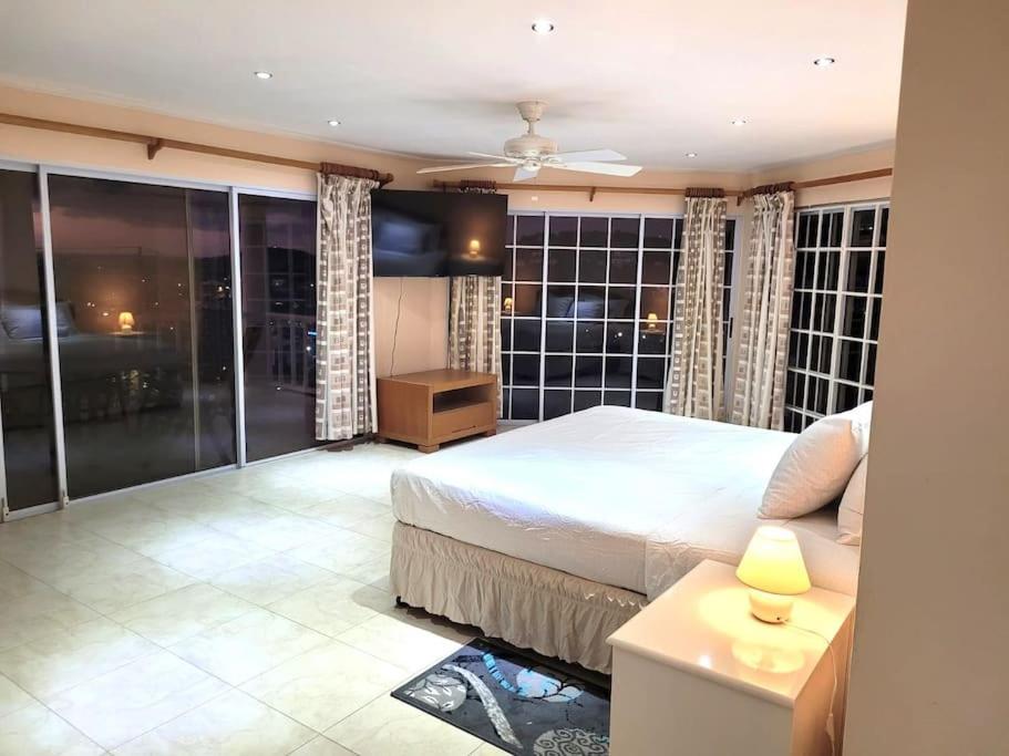 a bedroom with a large bed and a balcony at Marina View Villa in Gros Islet