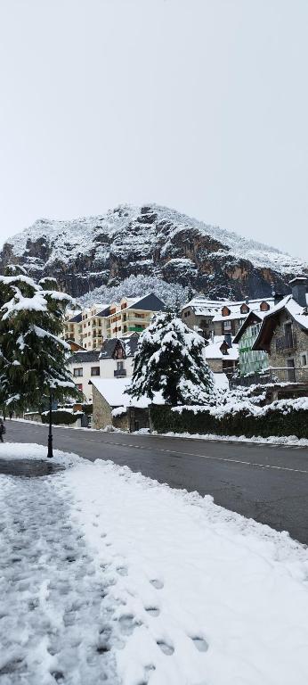 a snow covered street with houses in the background at Duplex Calle El Tillo in Escarrilla