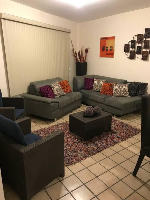 a living room with two couches and a rug at Excelente casa a unos pasos del blvd M. Alemán in Gómez Palacio