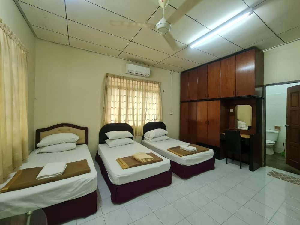 a hotel room with two beds and a desk at Paka Seaview Inn in Paka