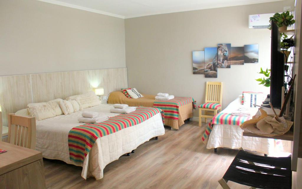 um quarto de hotel com duas camas e duas cadeiras em Augusta 7 em Salta
