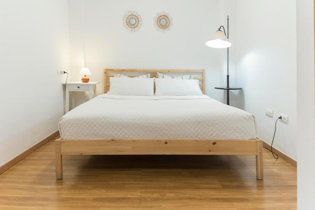 a bedroom with a large bed with white sheets at San Justo 3 in Huelva