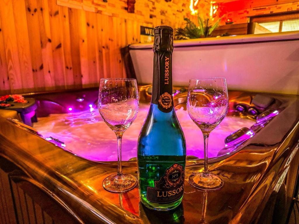 eine Flasche Wein und zwei Gläser auf einer Bar in der Unterkunft Spa Residence Családi Wellness Apartman in Veszprémfajsz