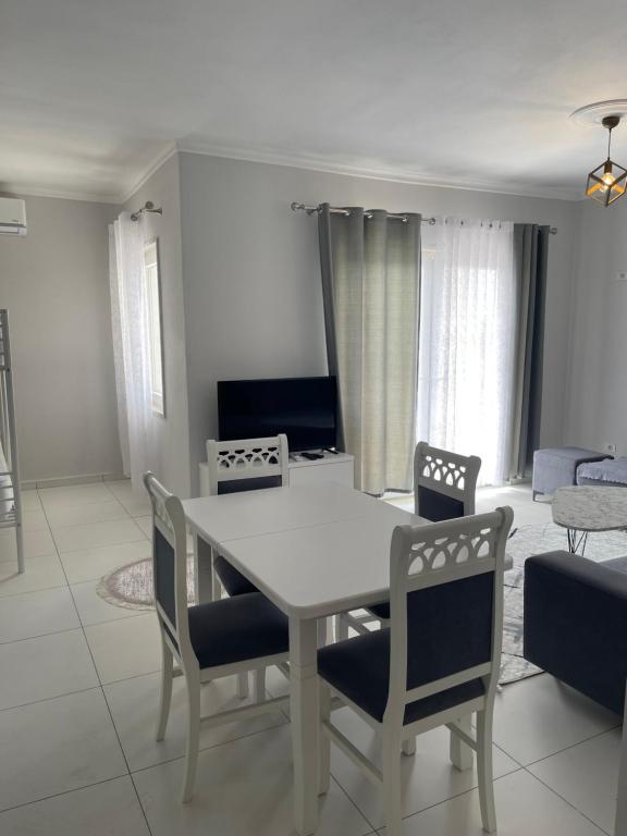 een witte tafel en stoelen in de woonkamer bij Fishta hotels in Velipojë