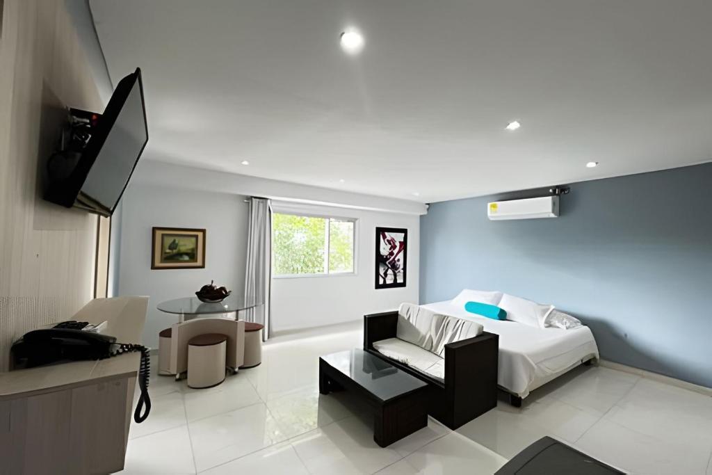 a bedroom with a bed and a living room at Lagos Apartaestudios x2 in Barranquilla
