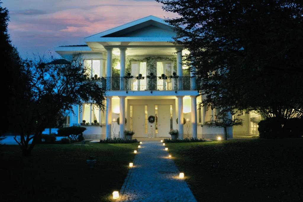 Magnago的住宿－Villa Patrizia B&B，院子里有灯的大白色房子