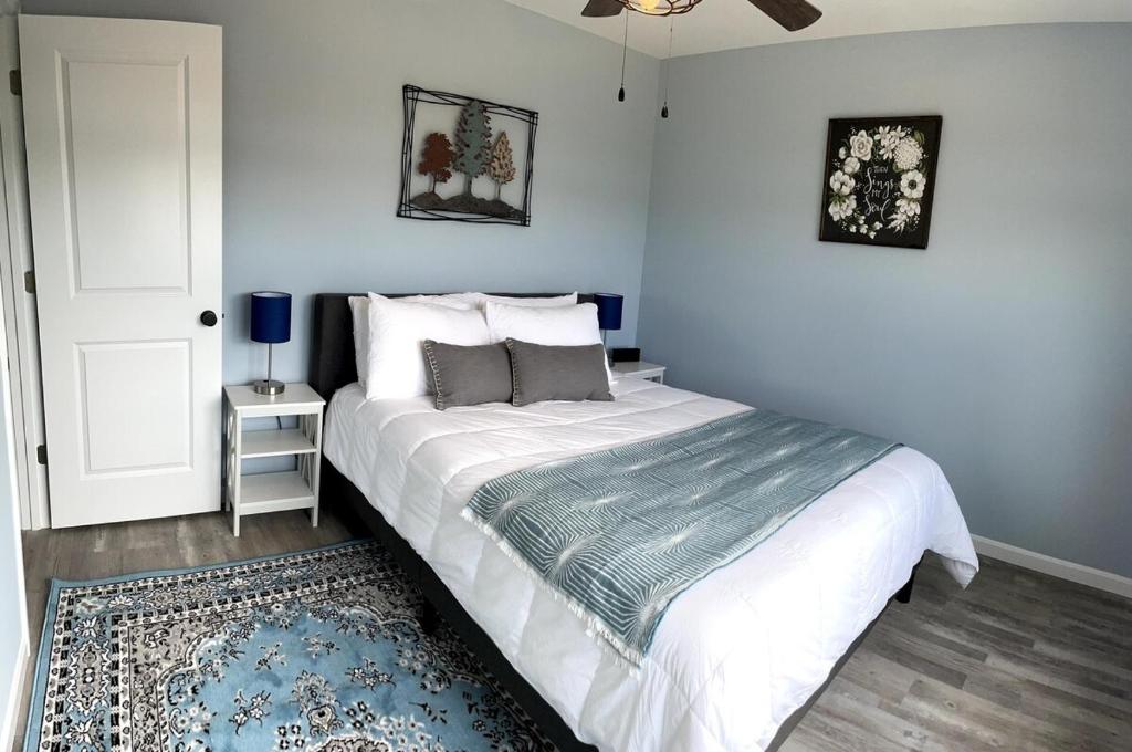 een slaapkamer met een wit bed en een blauw tapijt bij 100 Acre Relaxing Retreat Near Ark- The Woodlands in Williamstown