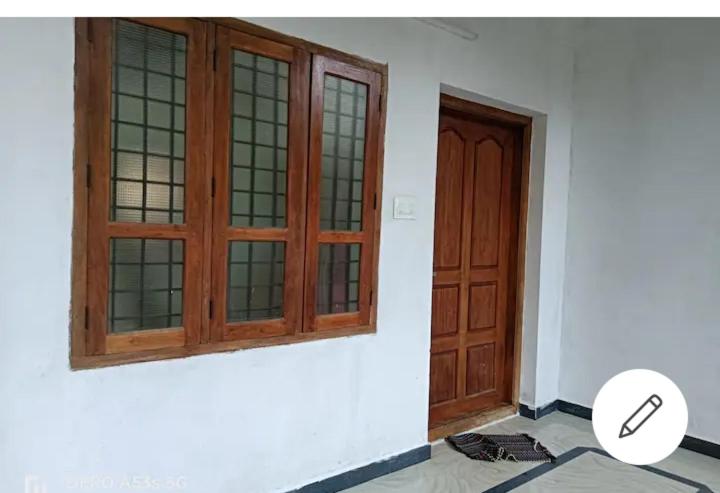 a pair of wooden doors in a room at Sree Paramahamsa in Varkala