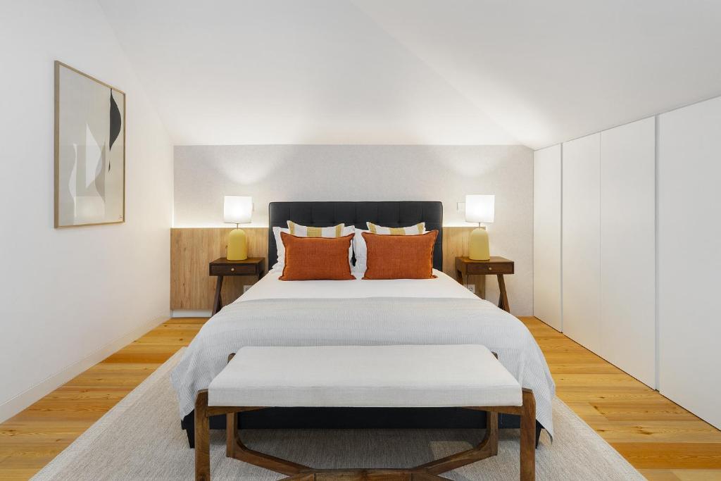 een slaapkamer met een groot wit bed met oranje kussens bij WHome Lisbon Skyline Penthouse Luxury Living View, AC & Elevator in Lissabon