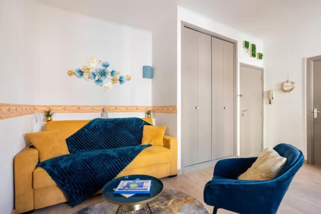 a living room with a yellow couch and a blue chair at L'apparté Marinoni Classé-Climatisé-WIFI-Mer in Beaulieu-sur-Mer