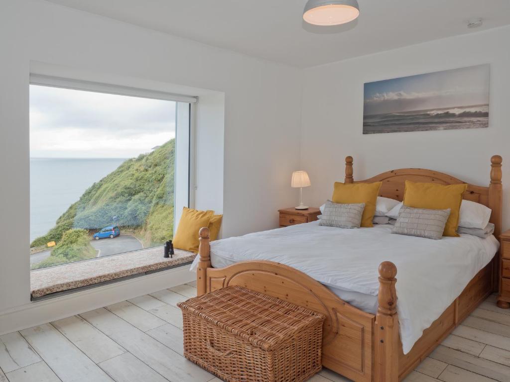 a bedroom with a bed and a large window at Brigydon Tresaith in Penbryn